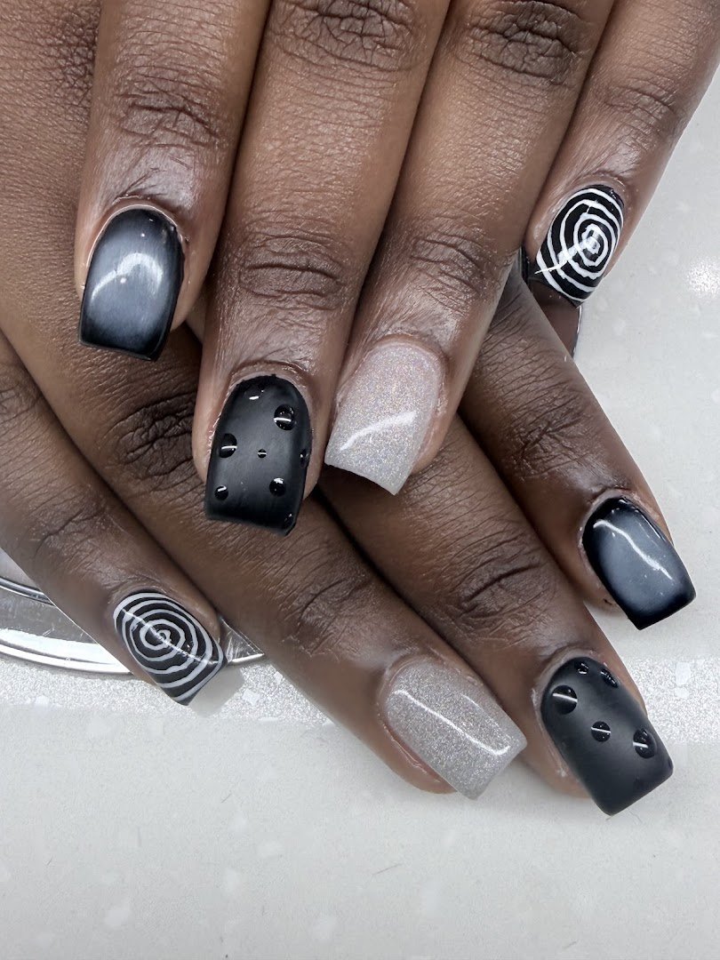 Acrylic nails being shaped at a salon table.